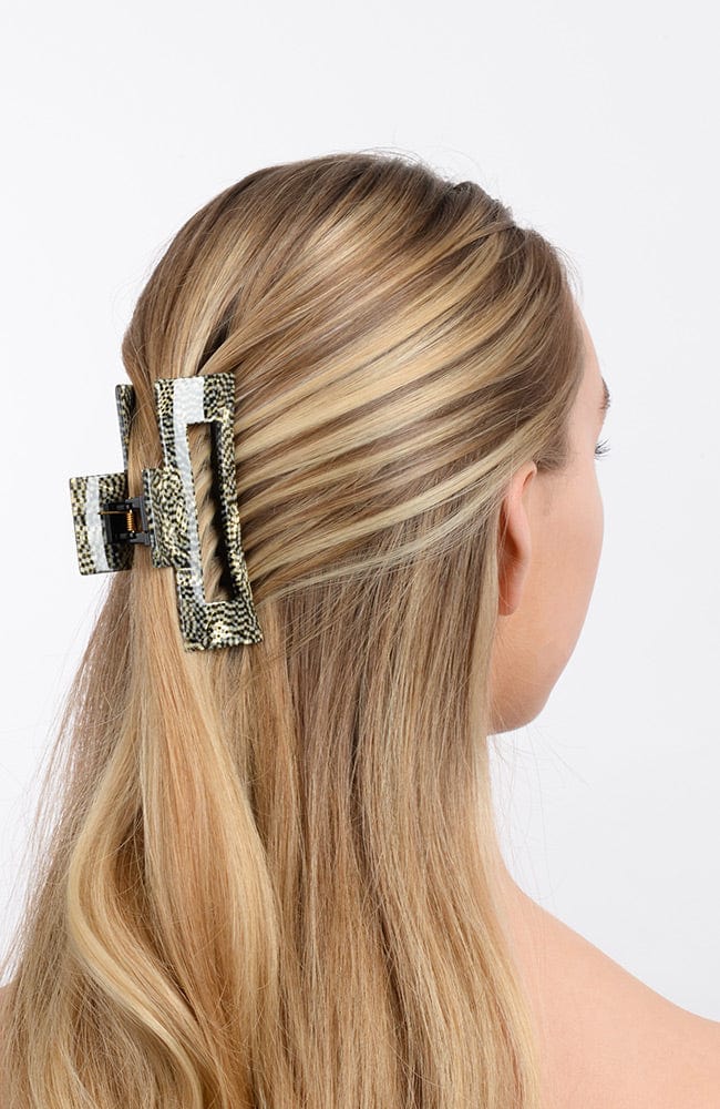 large hair clip with a cutout design holding hair up in a half up half down hair style
